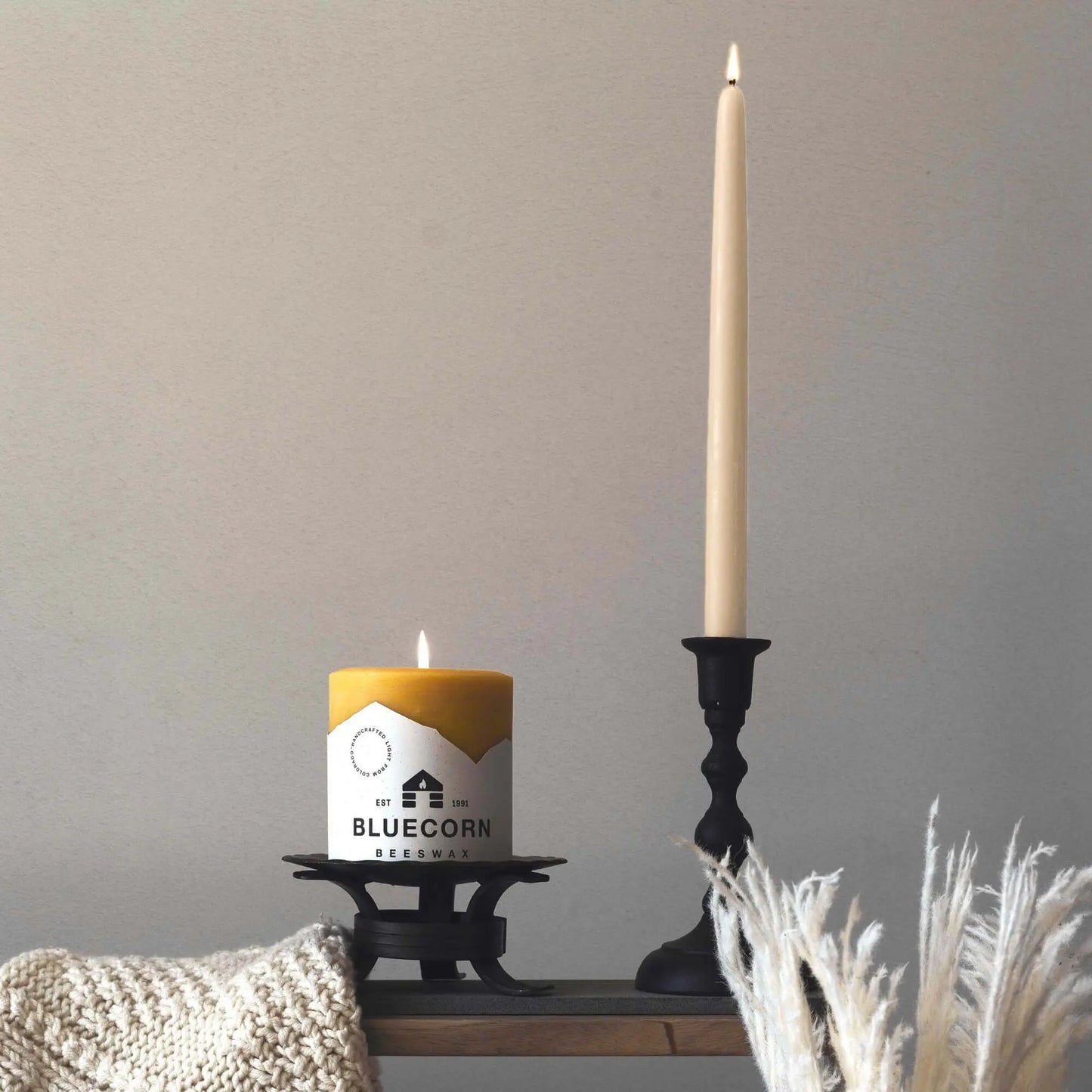 ivory beeswax taper candle and pillar candle on a table