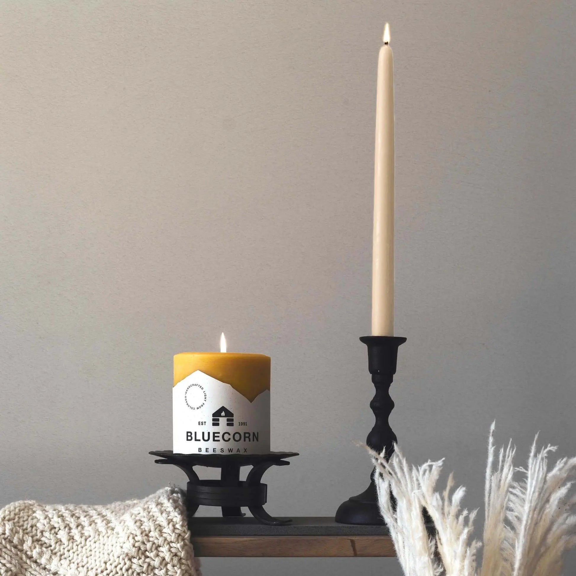 ivory beeswax taper candle and pillar candle on a table