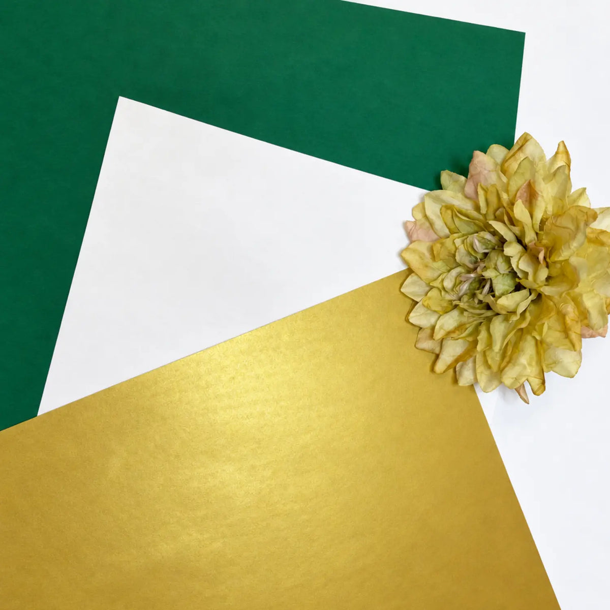 Japanese silk paper in green, white, and gold arranged for a St. Patrick’s Day craft