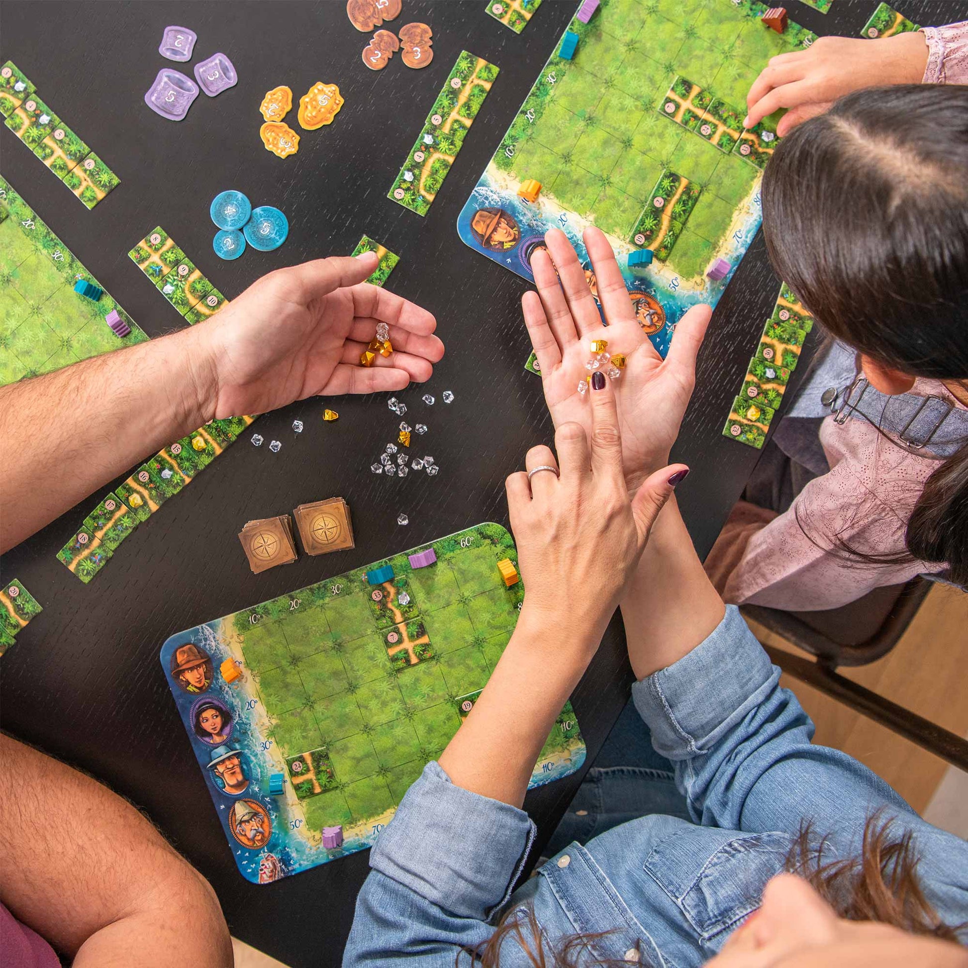 People playing a board game with colorful game pieces on a table