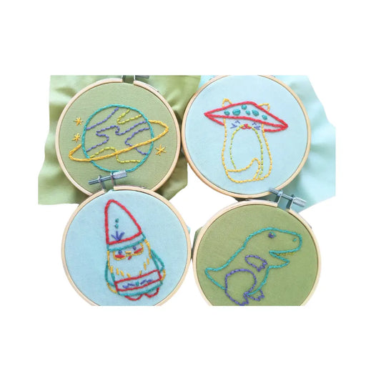 Four embroidery hoops with space-themed designs on a light green background