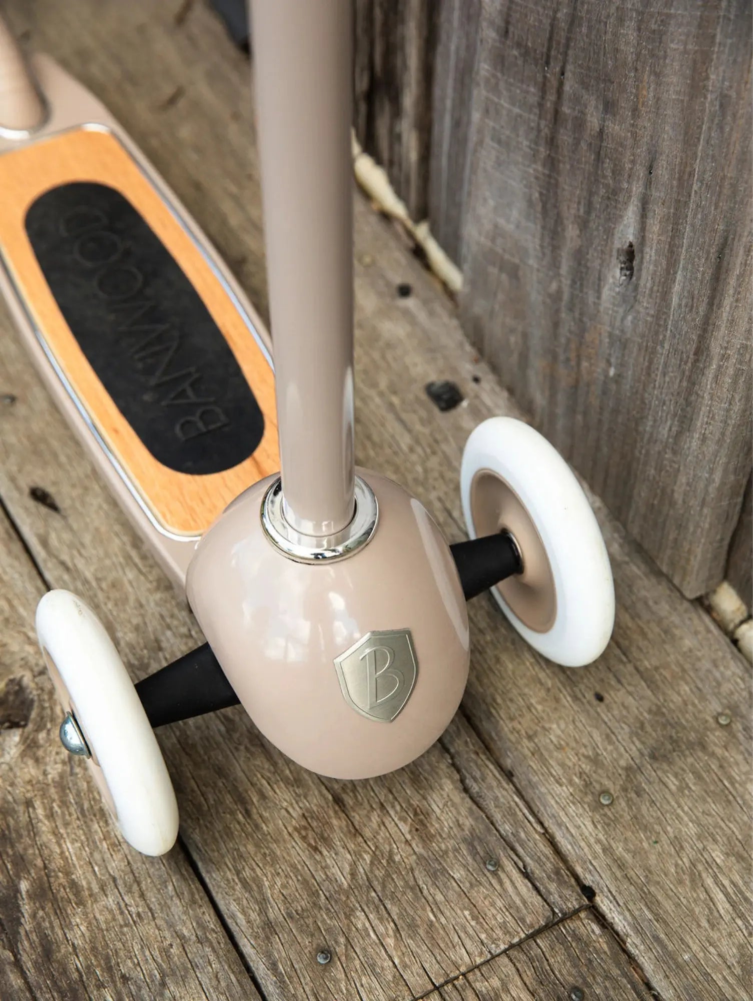 Children's scooter with white wheels on a wooden surface