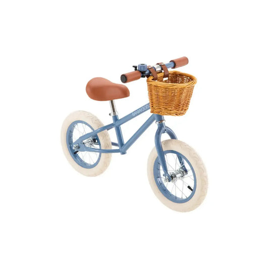 Children's balance bike with an angled view and a brown seat and basket on a white background