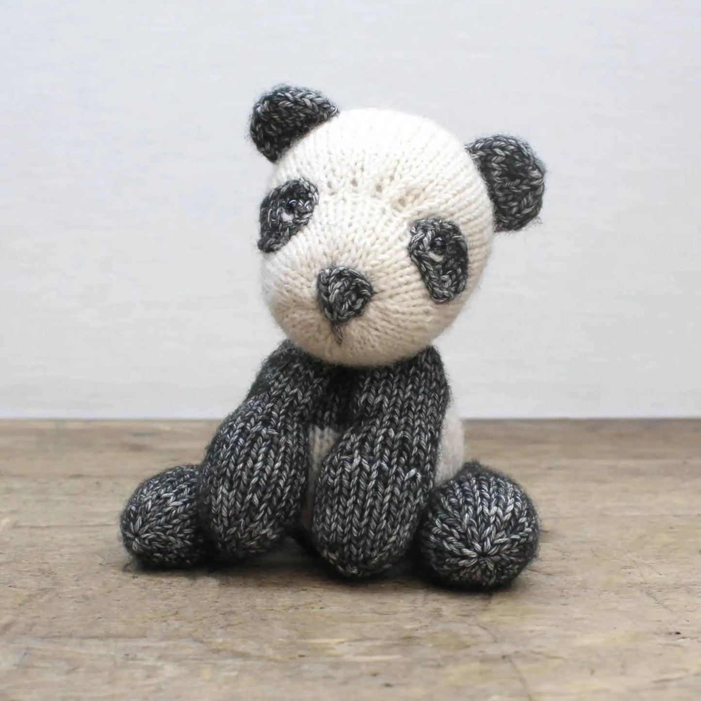 Front view of handmade knitted panda bear soft toy