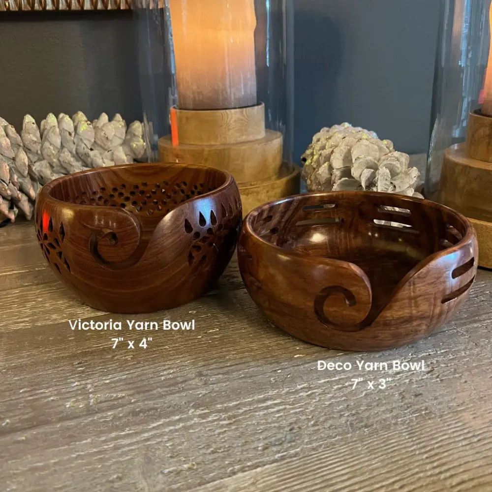 Two wooden yarn bowls labeled 'Victoria Yarn Bowl' and 'Deco Yarn Bowl' on a wooden surface.