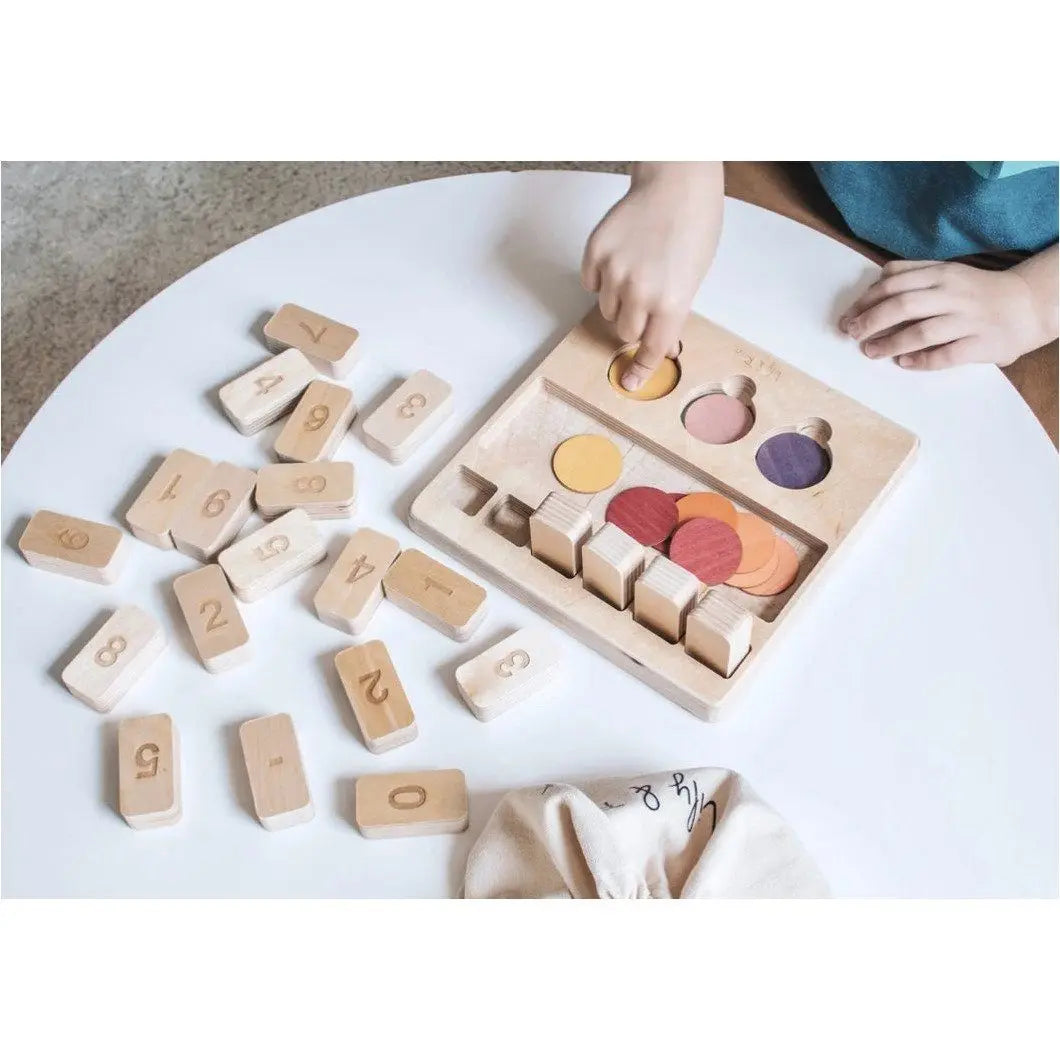 Child playing with wooden educational toys on a white surface