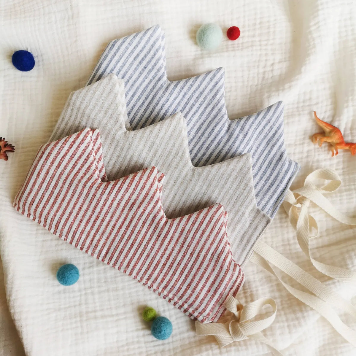 Striped natural linen dress-up crowns in red, beige, and blue striped with adjustable ties for children