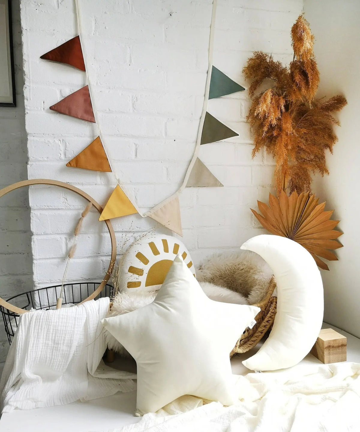 Soft linen pennant garland hanging in a neutral children’s playroom with natural decor and soft furnishings.
