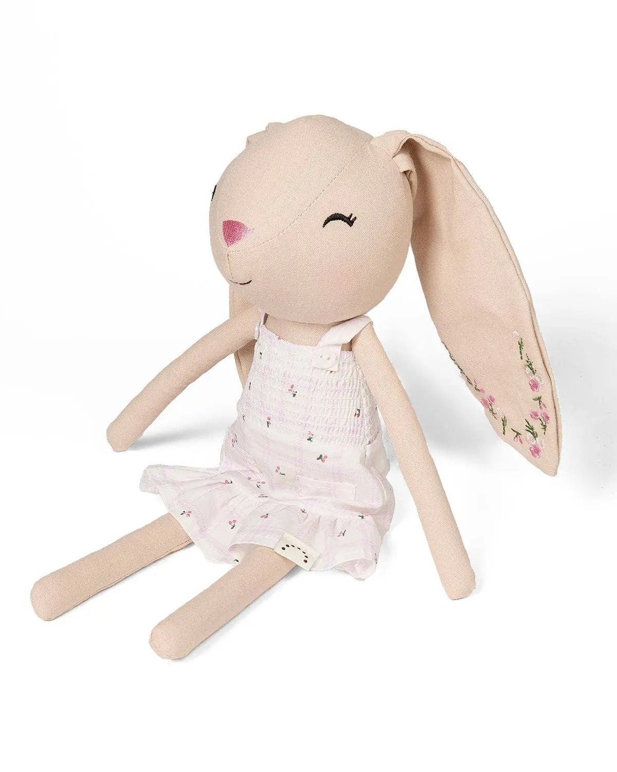 Toy rabbit with a pink dress on a white background