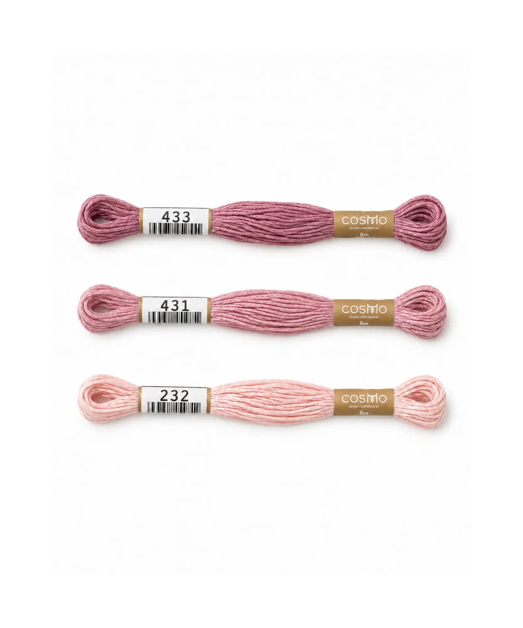 Three skeins of pink embroidery floss with labels on a white background