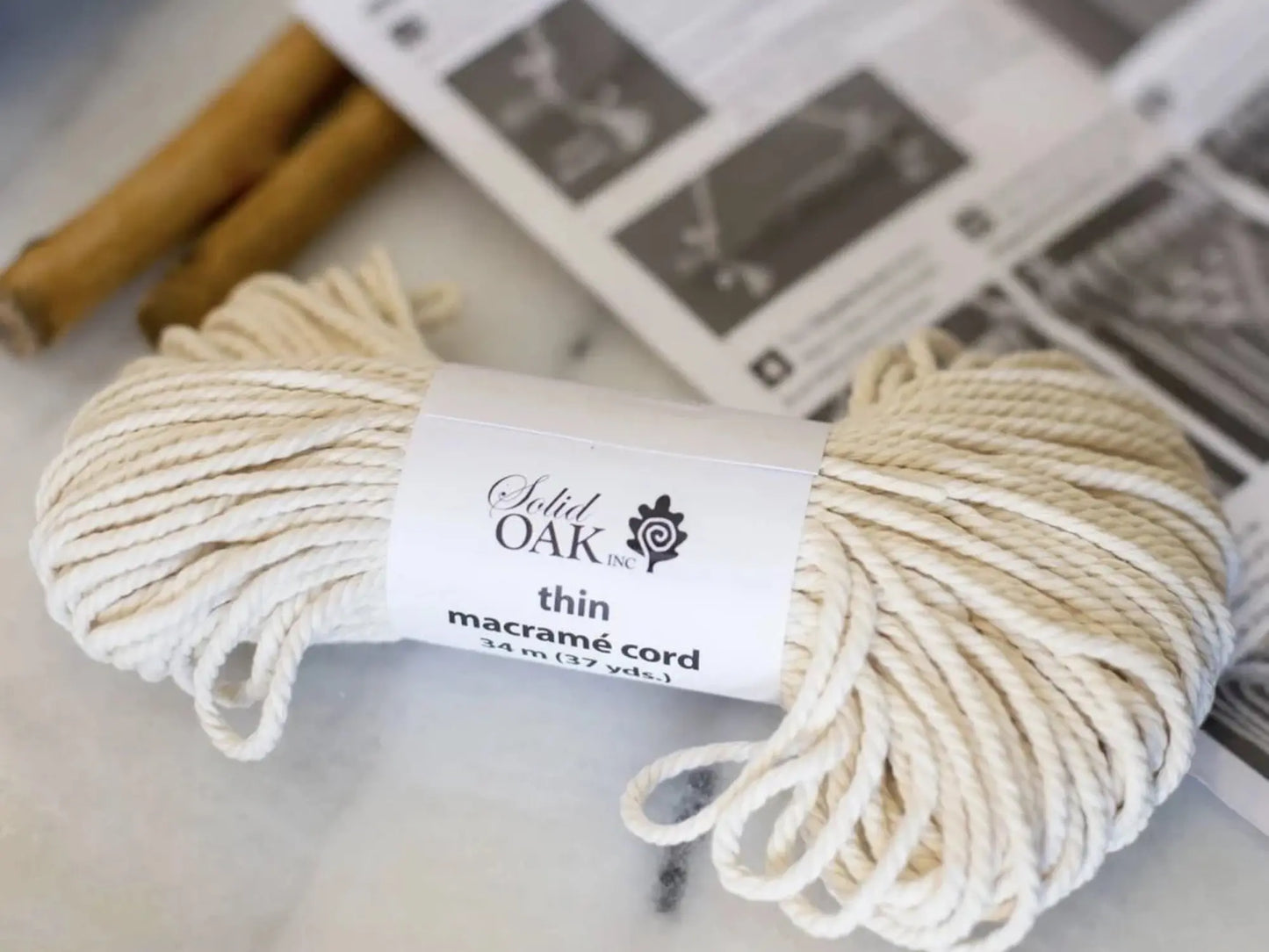 Ball of beige macrame cord with a label on a light background