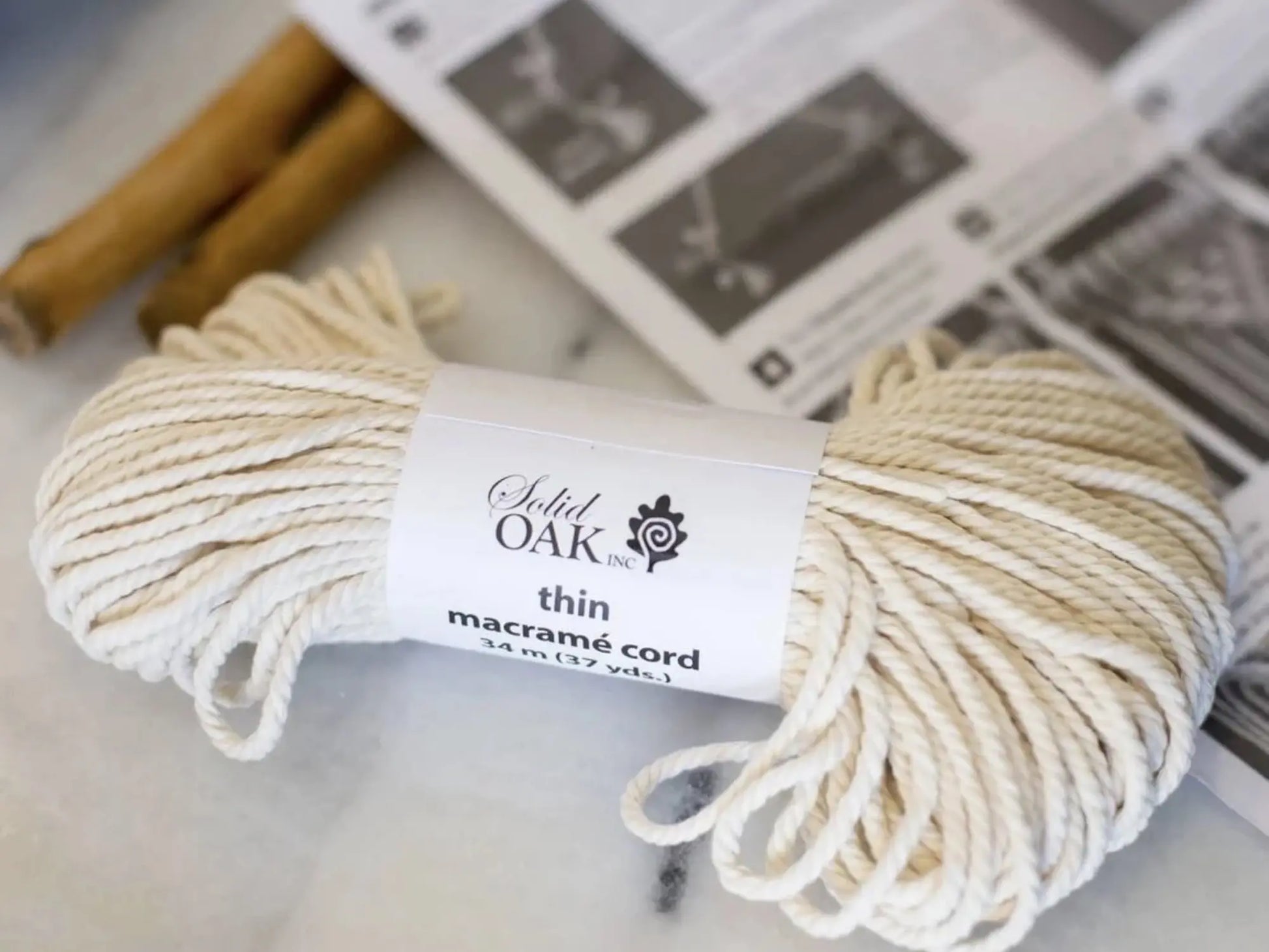 Ball of beige macrame cord with a label on a light background