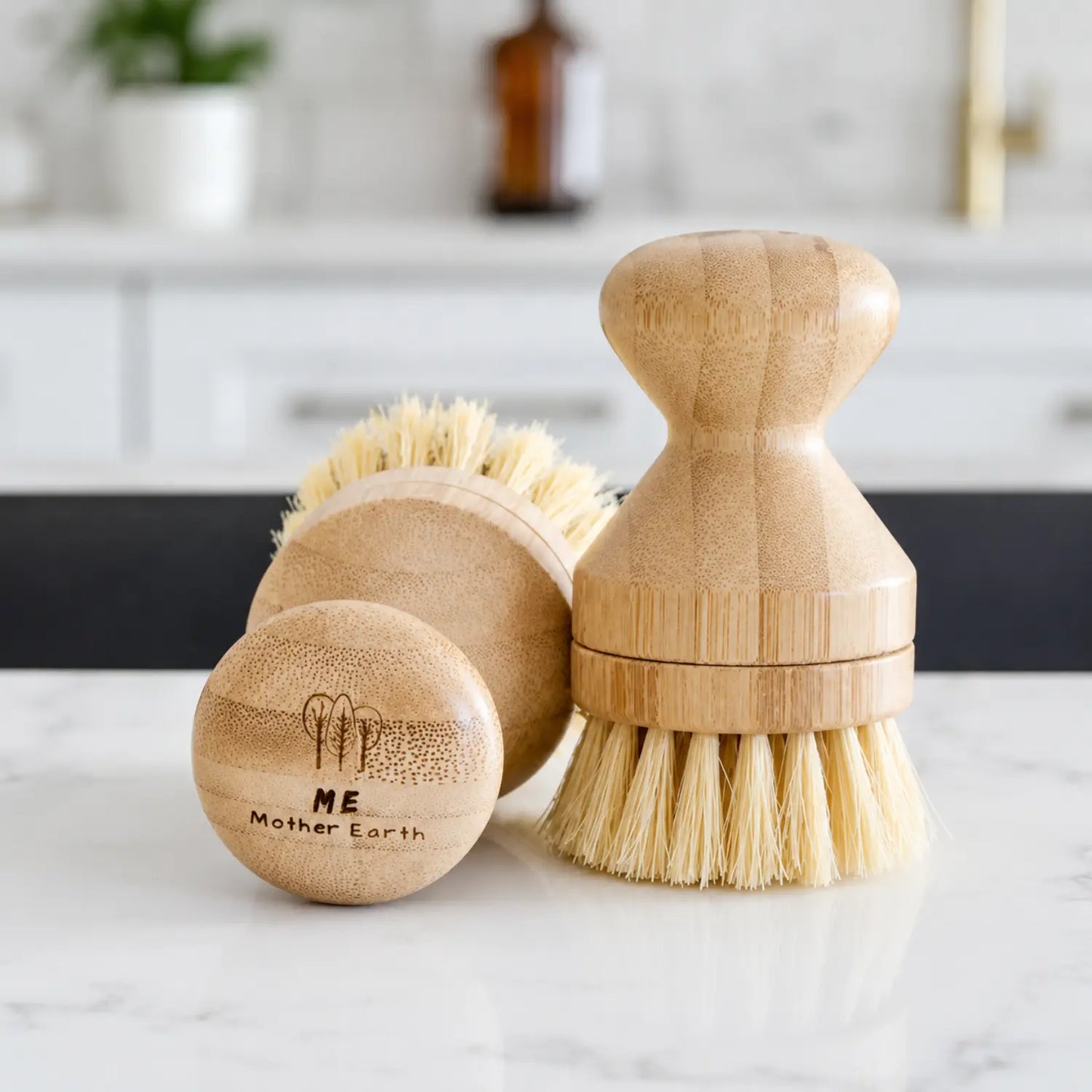 Modular bamboo dish brushes with natural sisal and palm fiber bristles on a bright kitchen counter.