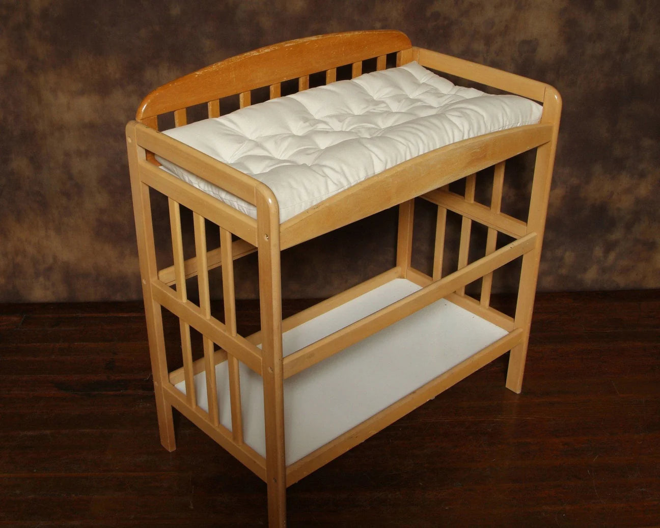 Natural Changing Table Pad made from eco-wool and organic cotton on a wooden changing table with wooden floor