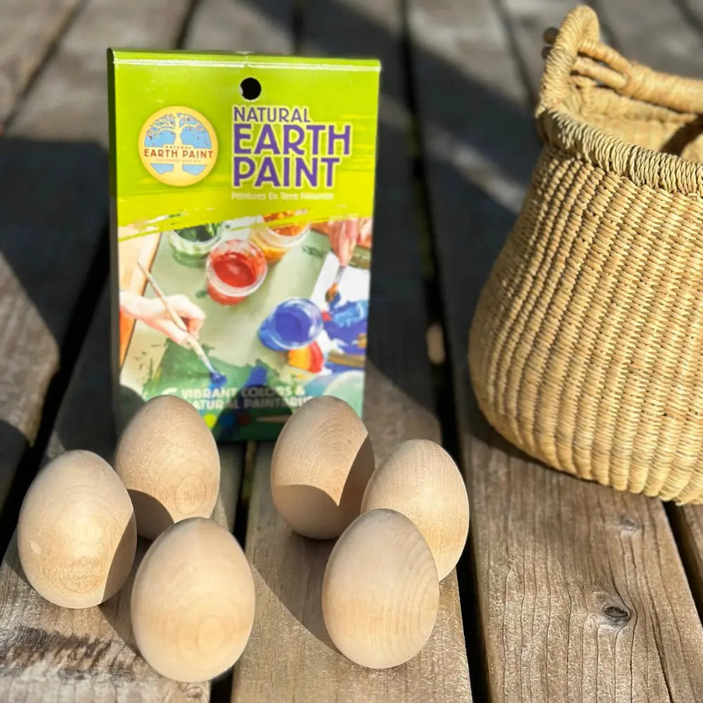 Natural Earth Paint packaging with wooden eggs on a wooden surface