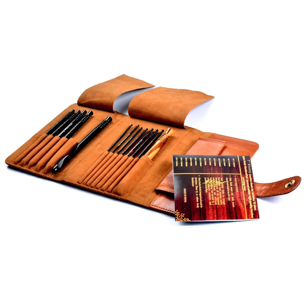 Set of black pens in a brown leather case with a book on a white background