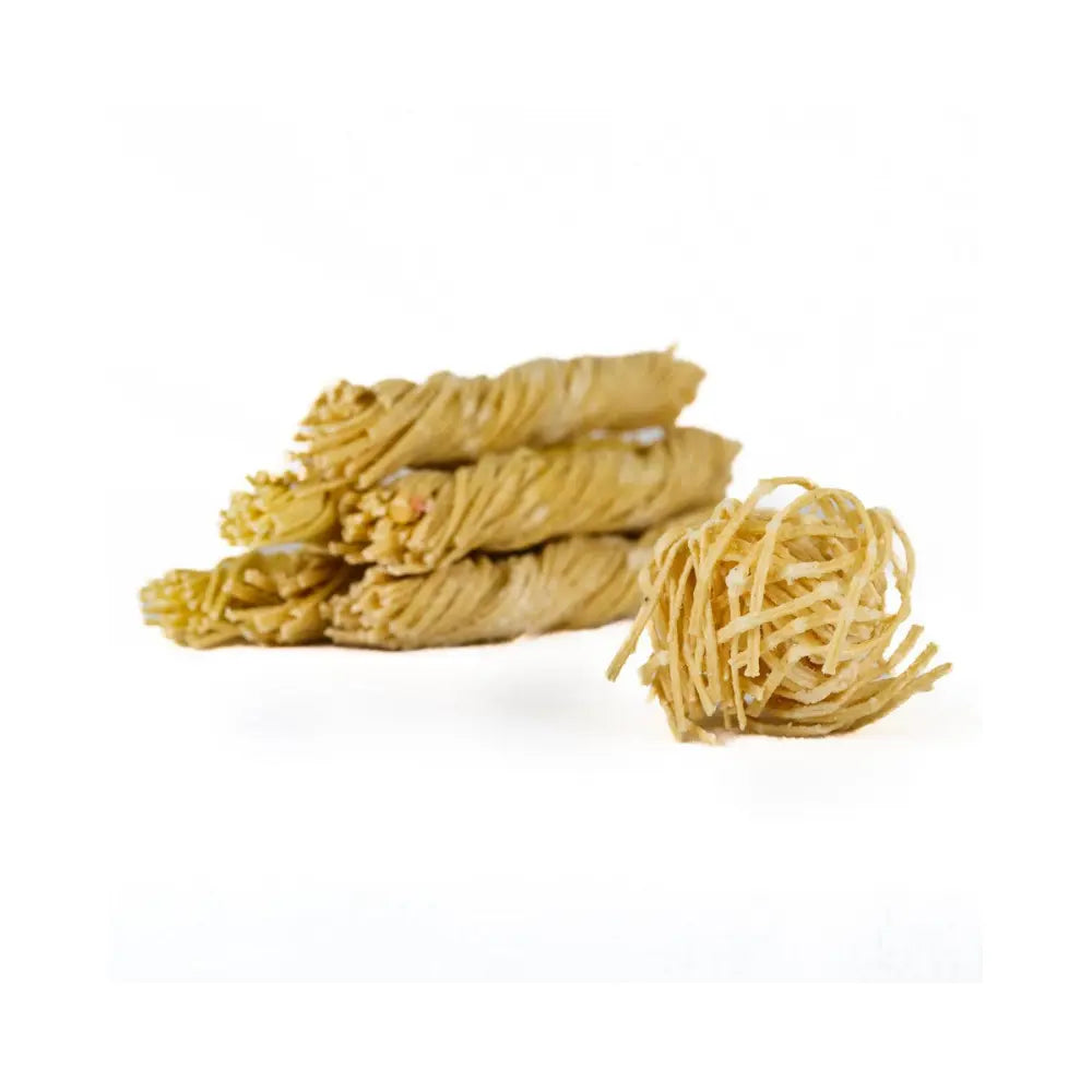Piles of beeswax soaked wick firestarters on a white background