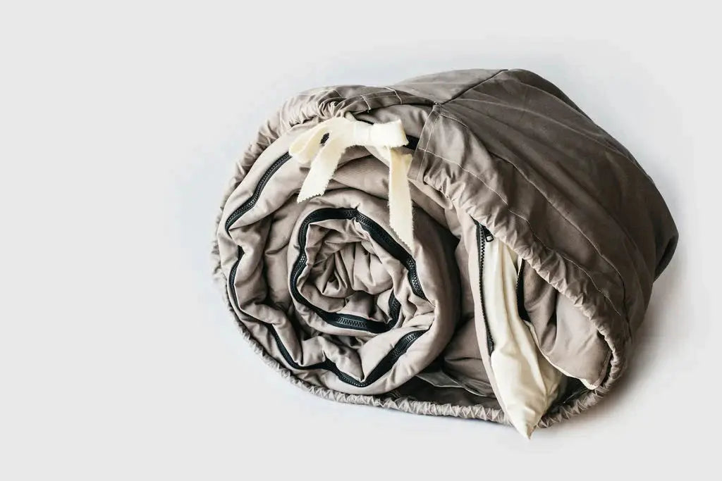  Cotton and Wool sleeping bag in duffle bag on light background