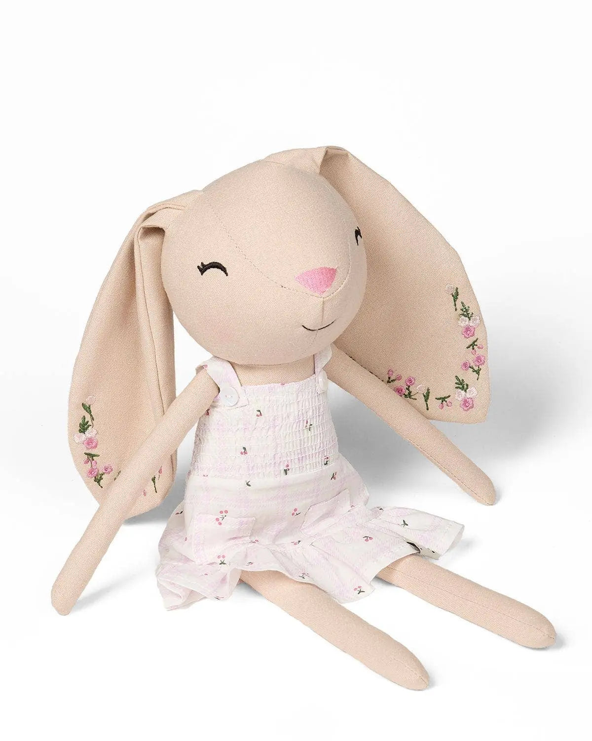 Stuffed bunny doll with a pink dress on a white background