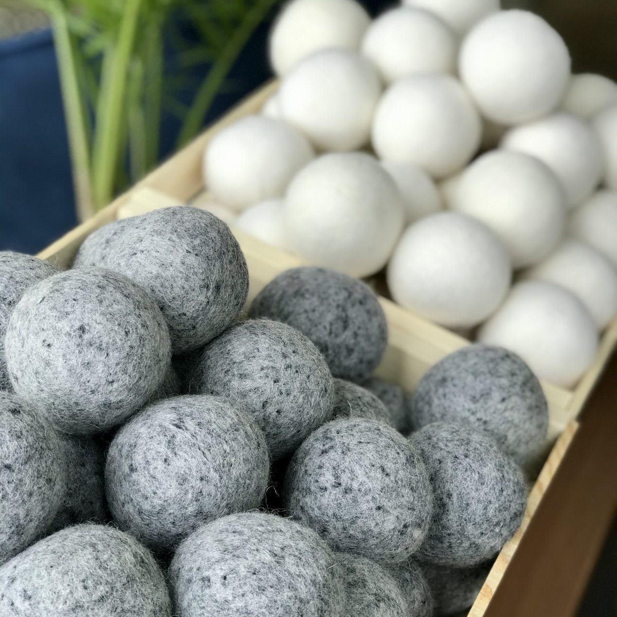 close up of gray and white wool dryer balls in wooden boxes