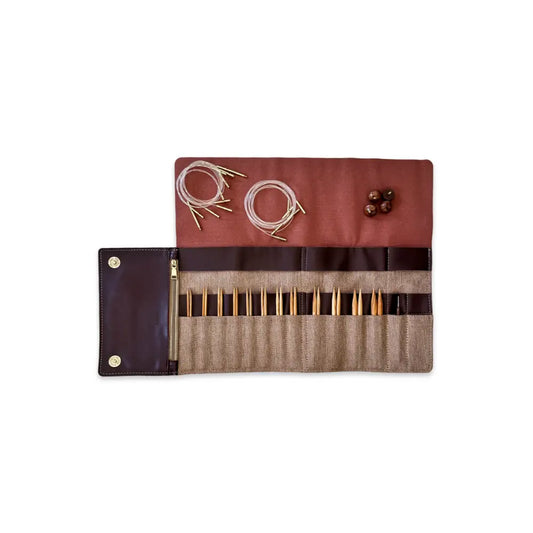 Knitting needle set with brown case on a white background