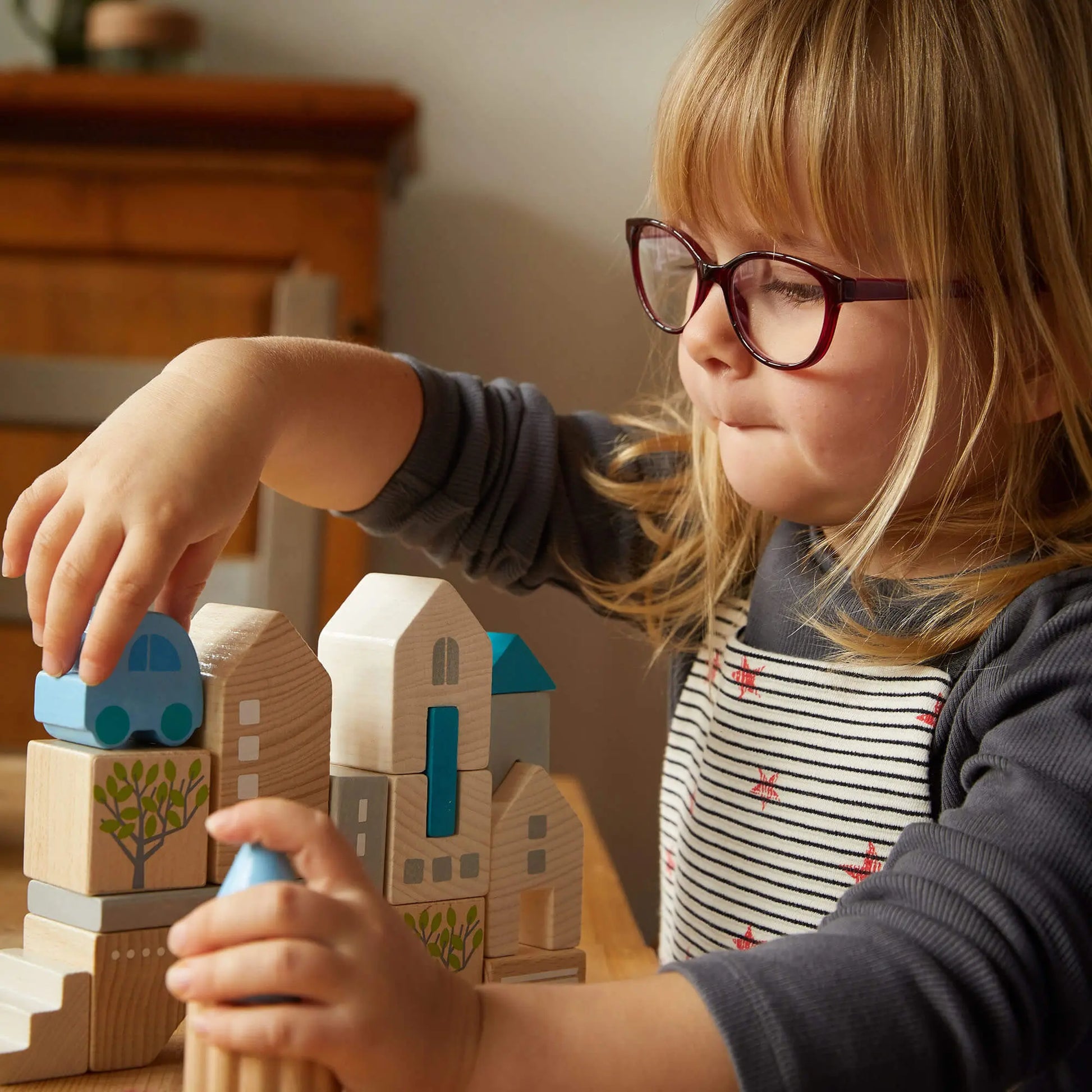 Preschool child stacking HABA Bad Rodach wooden building blocks, developing fine motor skills and imaginative play