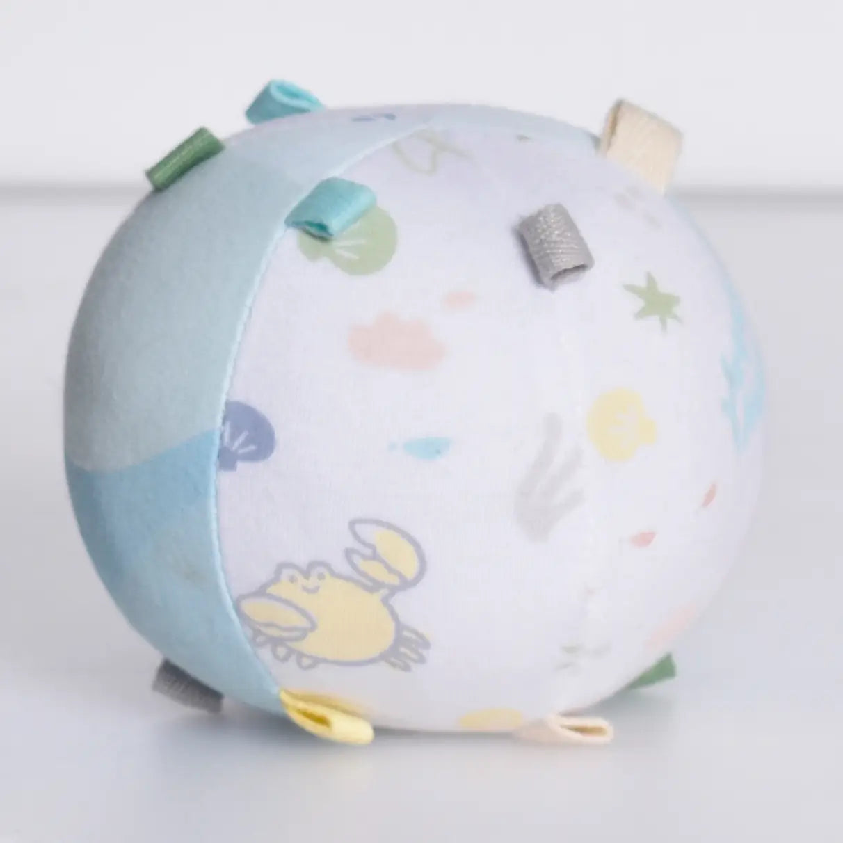 Organic cotton baby activity ball rattle angled view showing rounded shape and soft construction