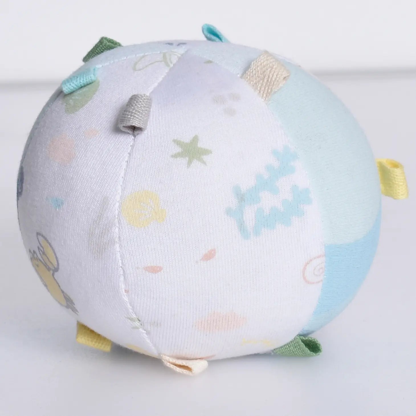 Organic cotton baby activity ball rattle side view showing fabric tabs for tactile exploration