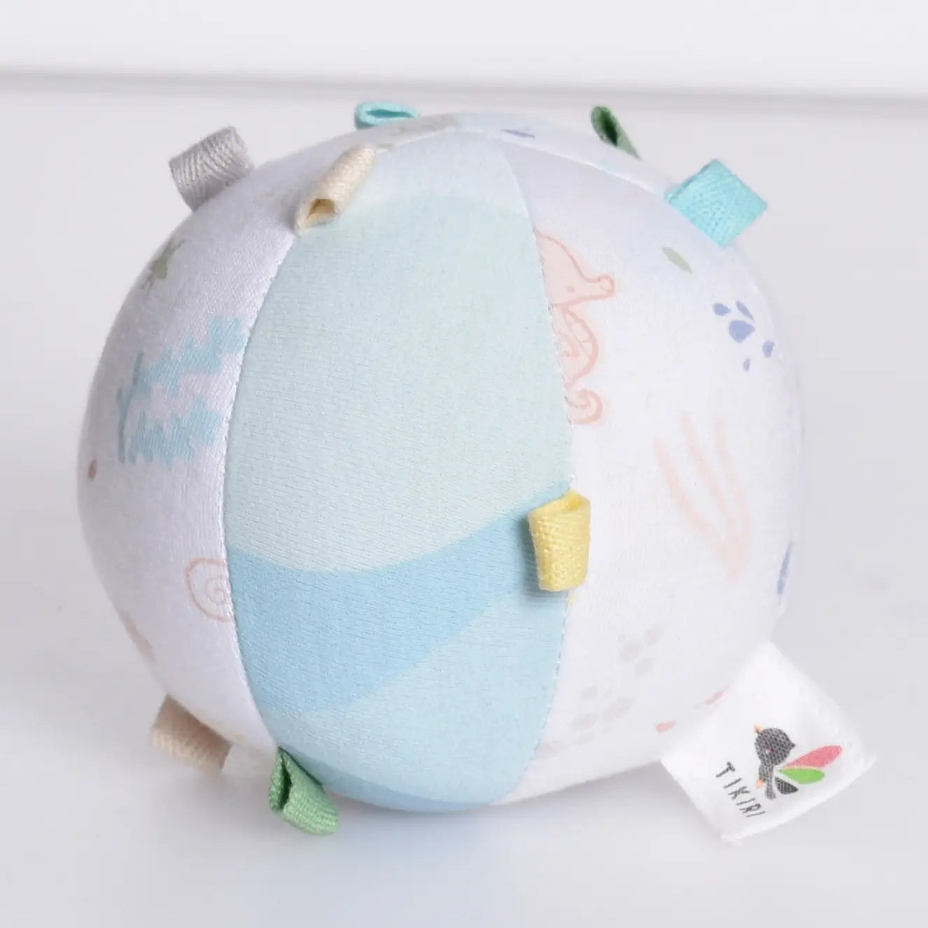Organic cotton baby activity ball rattle top view showing multiple textured tabs for sensory play