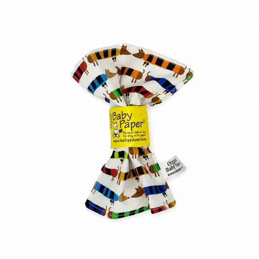 Organic cotton baby crinkle toy with colorful striped dachshund print and yellow Baby Paper label.