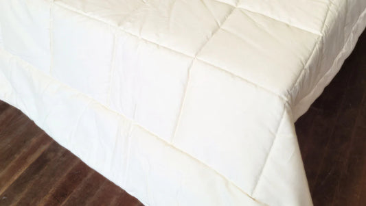 Close-up of quilted stitching on organic cotton comforter showing structured square pattern