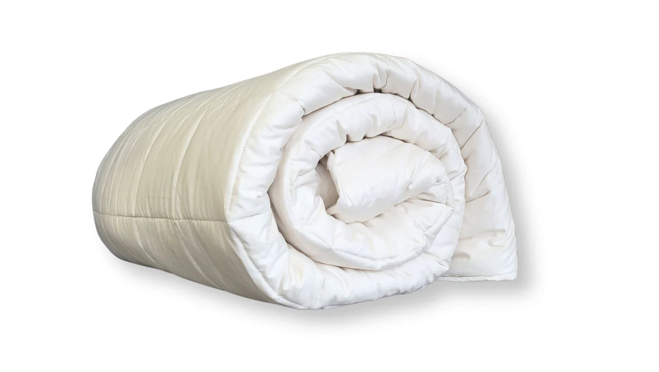 Folded organic cotton comforter stacked to show thickness and layered construction
