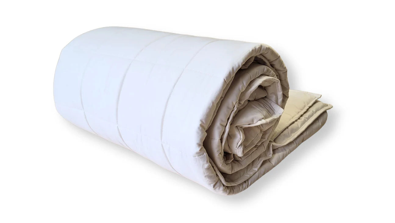 Organic cotton comforter rolled tightly displaying loft and natural cotton fill