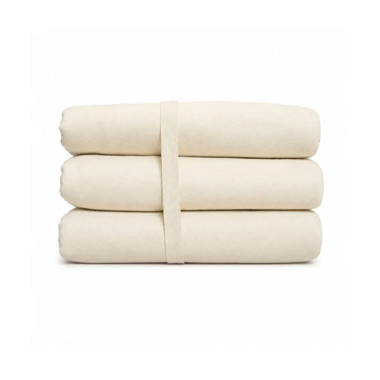 Folded organic cotton mattress protector in natural cream on a white background
