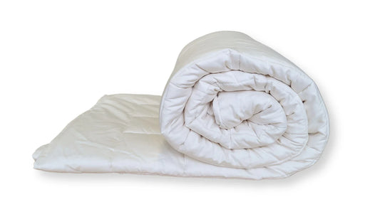 Quilted organic cotton toddler comforter folded and rolled showing natural cotton fill and soft structure