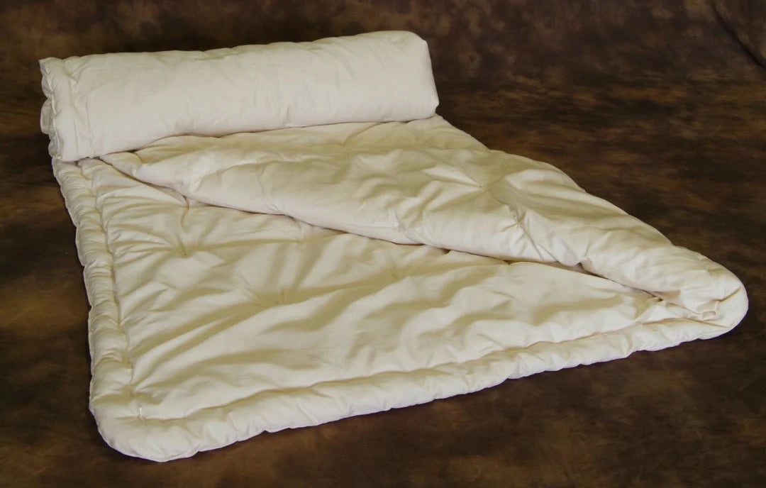 Folded and rolled organic wool comforter showing thickness and natural loft