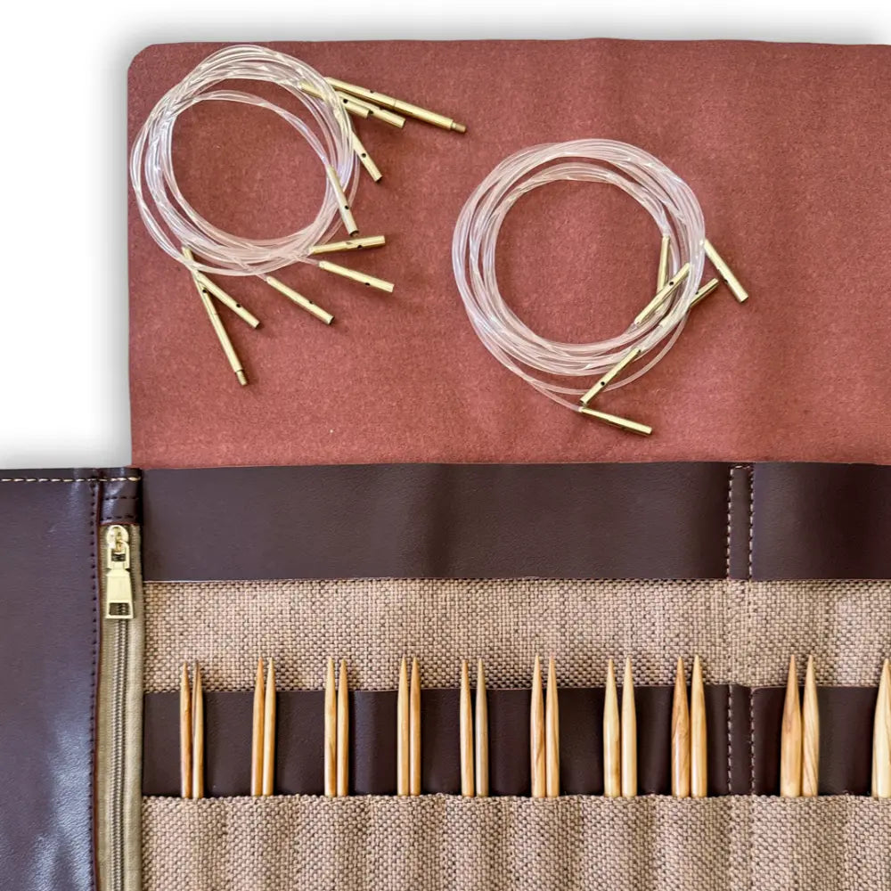 Knitting needle set with brown and beige case on a white background