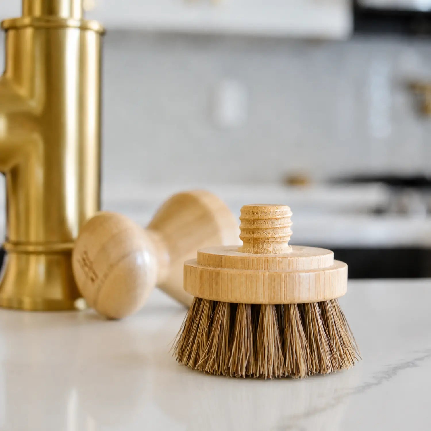 Dark palm and sisal replacement head for a modular bamboo pot scrubber on a marble counter.