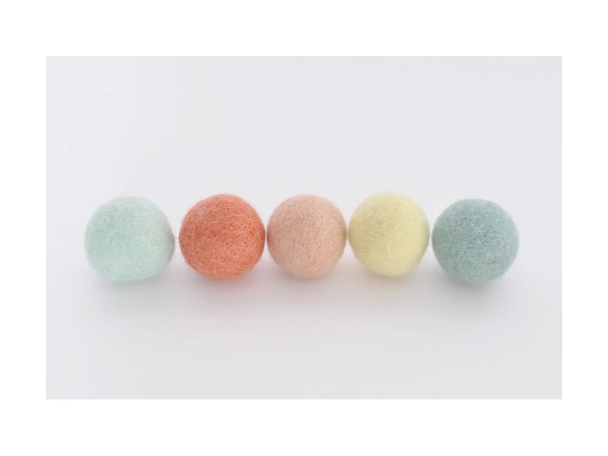 pastel felt wool balls in coral peach mint and yellow for garlands wreaths and seasonal craft decorations