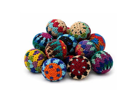A pile of colorful crocheted Faire Trade balls with textured, handmade patterns, arranged on a clean white background.