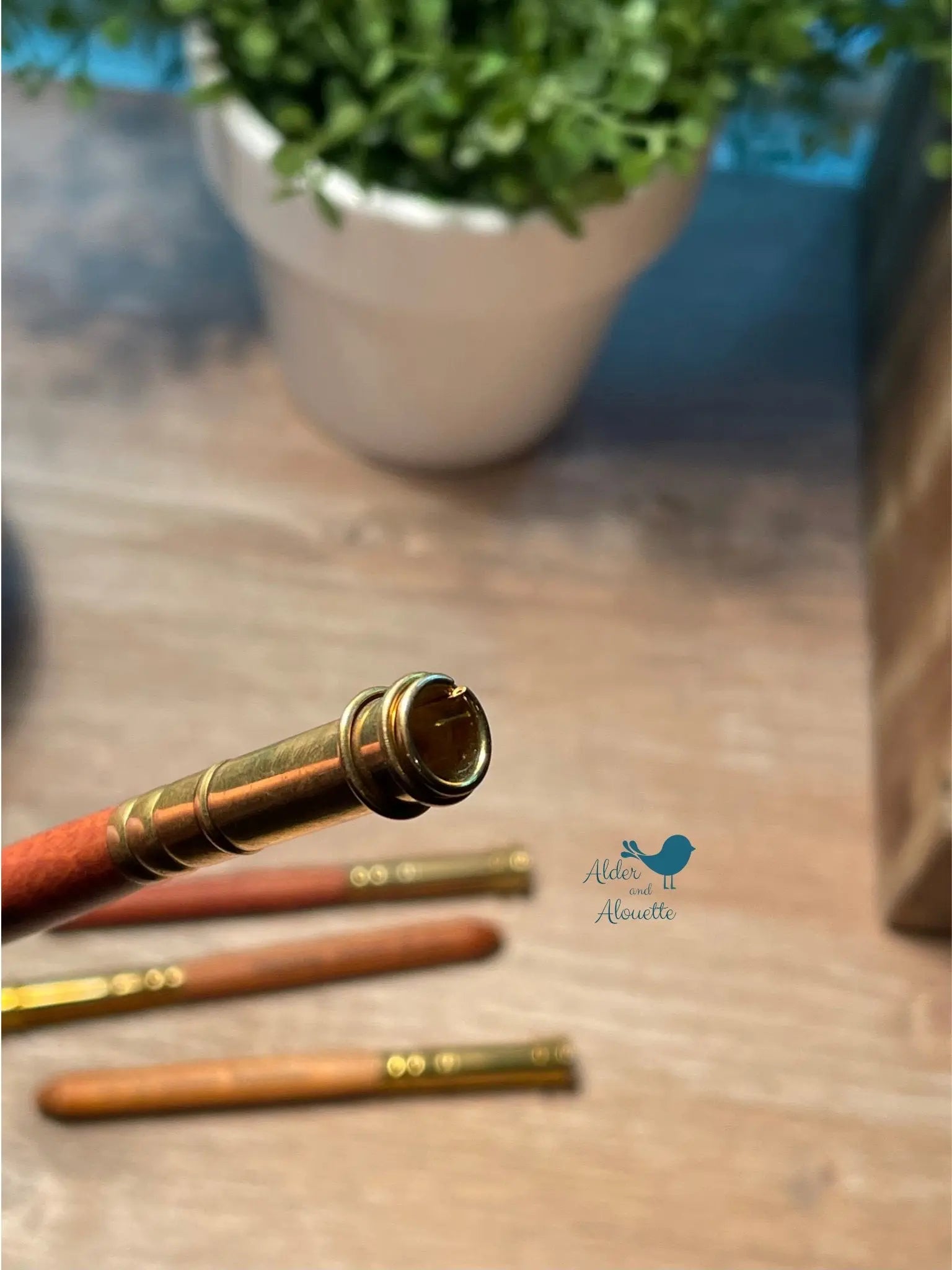 close up of brass tip on wooden pencil extender designed to hold thick colored pencils securely