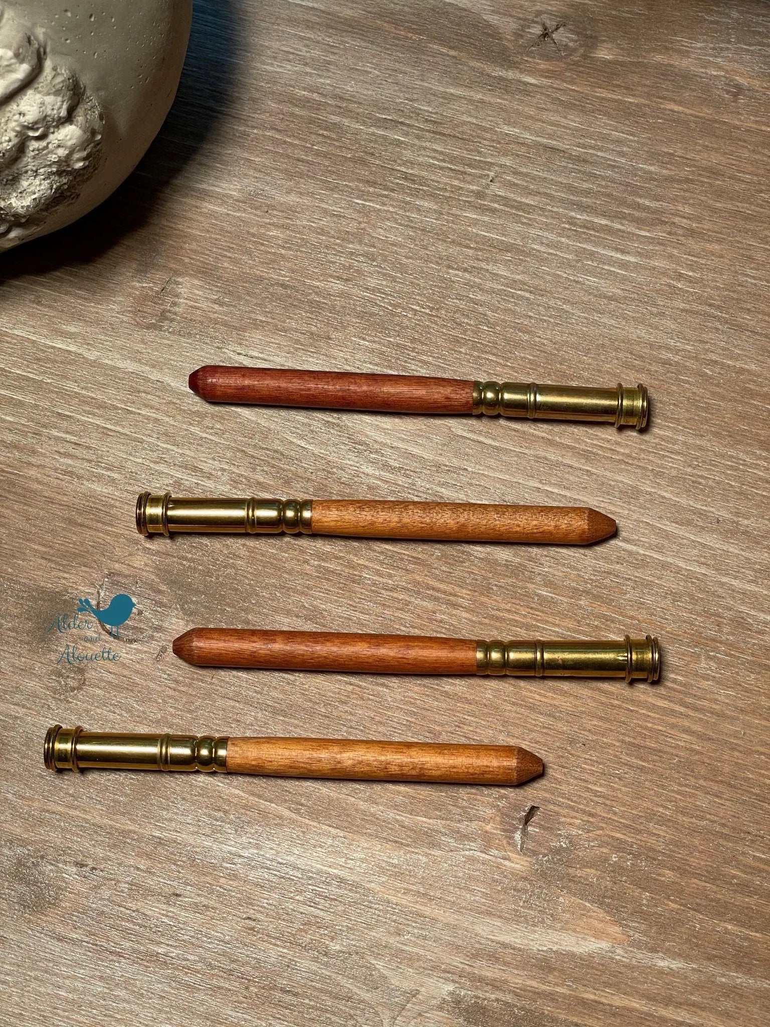 set of wooden pencil extenders for thick colored pencils showing multiple sizes and natural wood variation