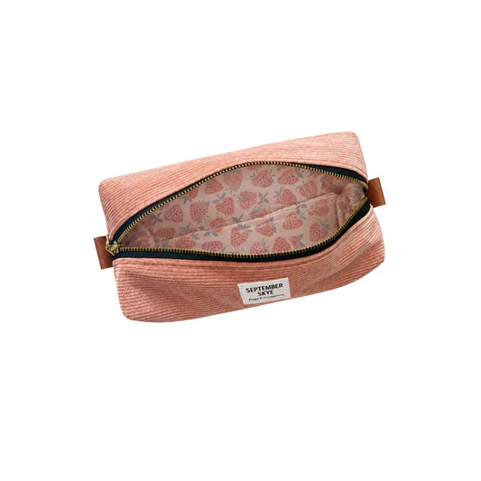An open dusty pink corduroy pencil pouch bag with a strawberry patterned lining