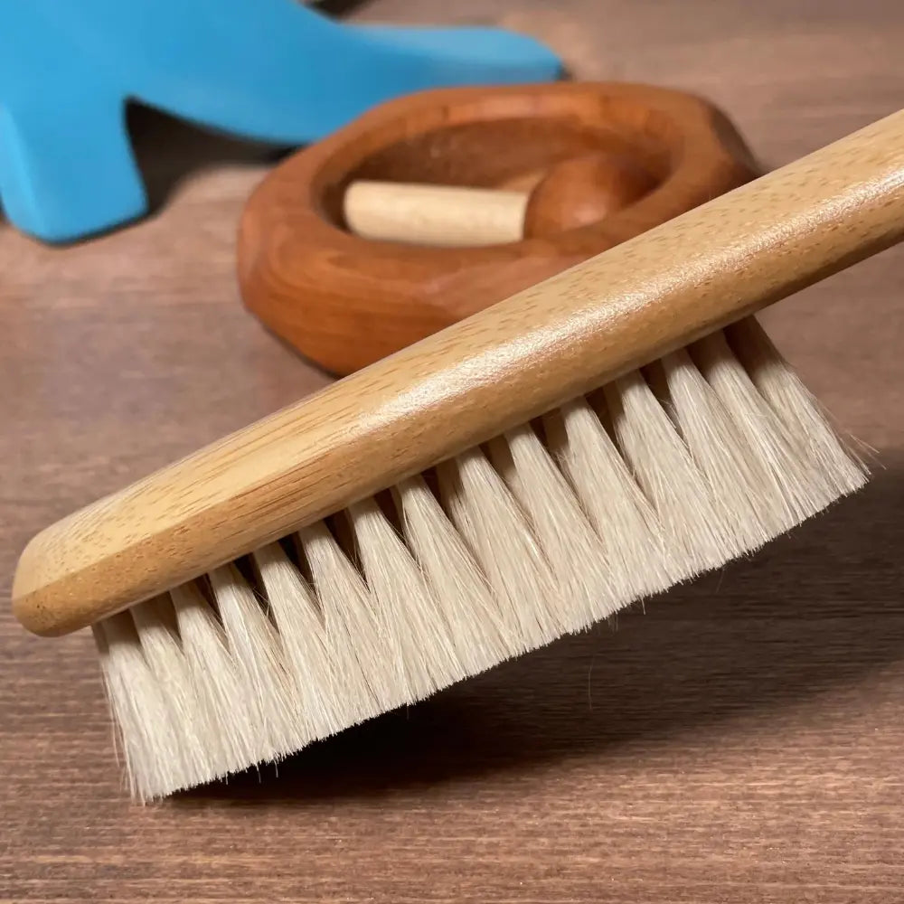 Wooden baby brush with bristles on a wooden surface
