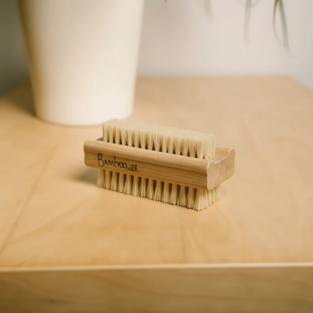 Bamboo nail brush on a wooden surface with a white cup in the background