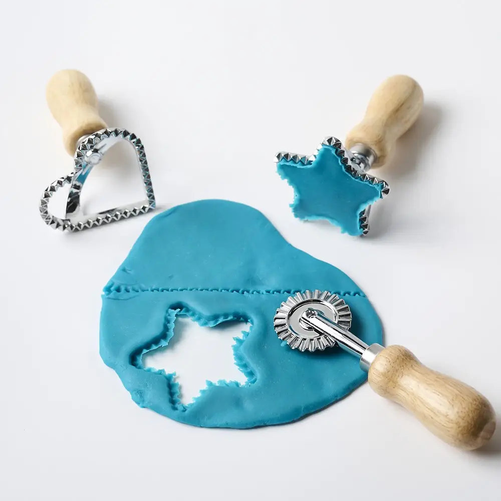 Star cutter and rolling dough wheel used with blue play dough for fine motor sensory play