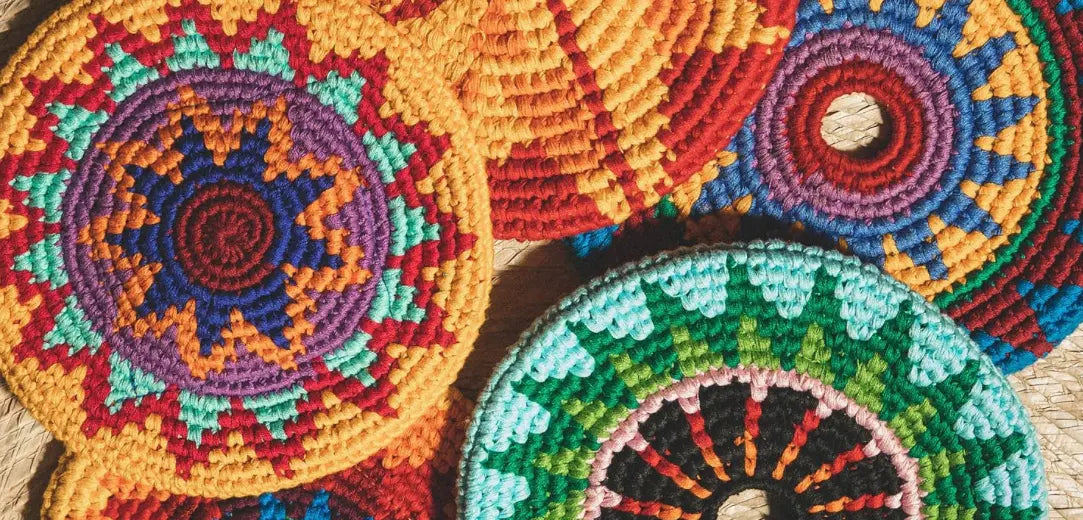 Multiple colorful woven soft frisbees for kids on a woven surface