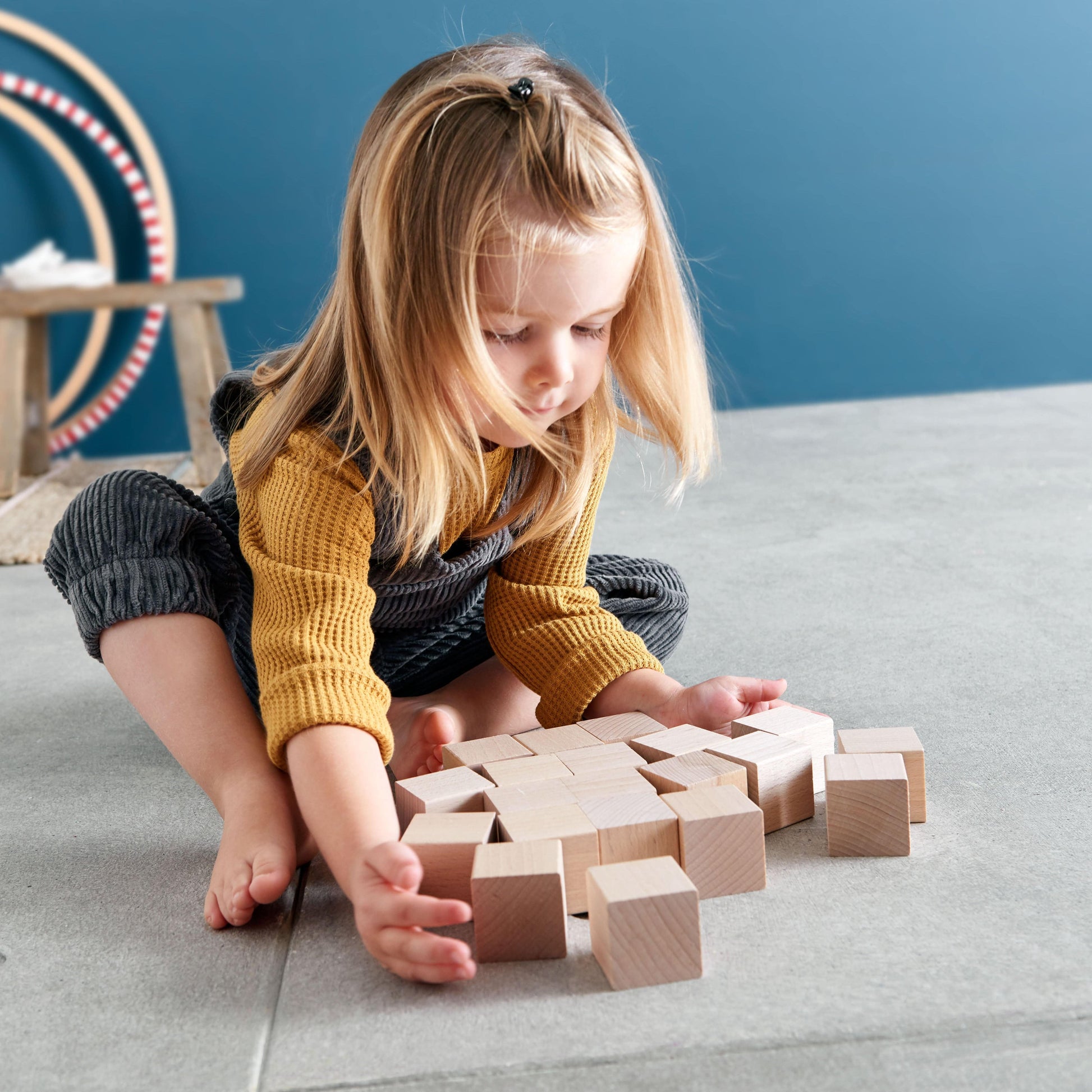 Preschool child building structures with wooden blocks and experimenting with shapes