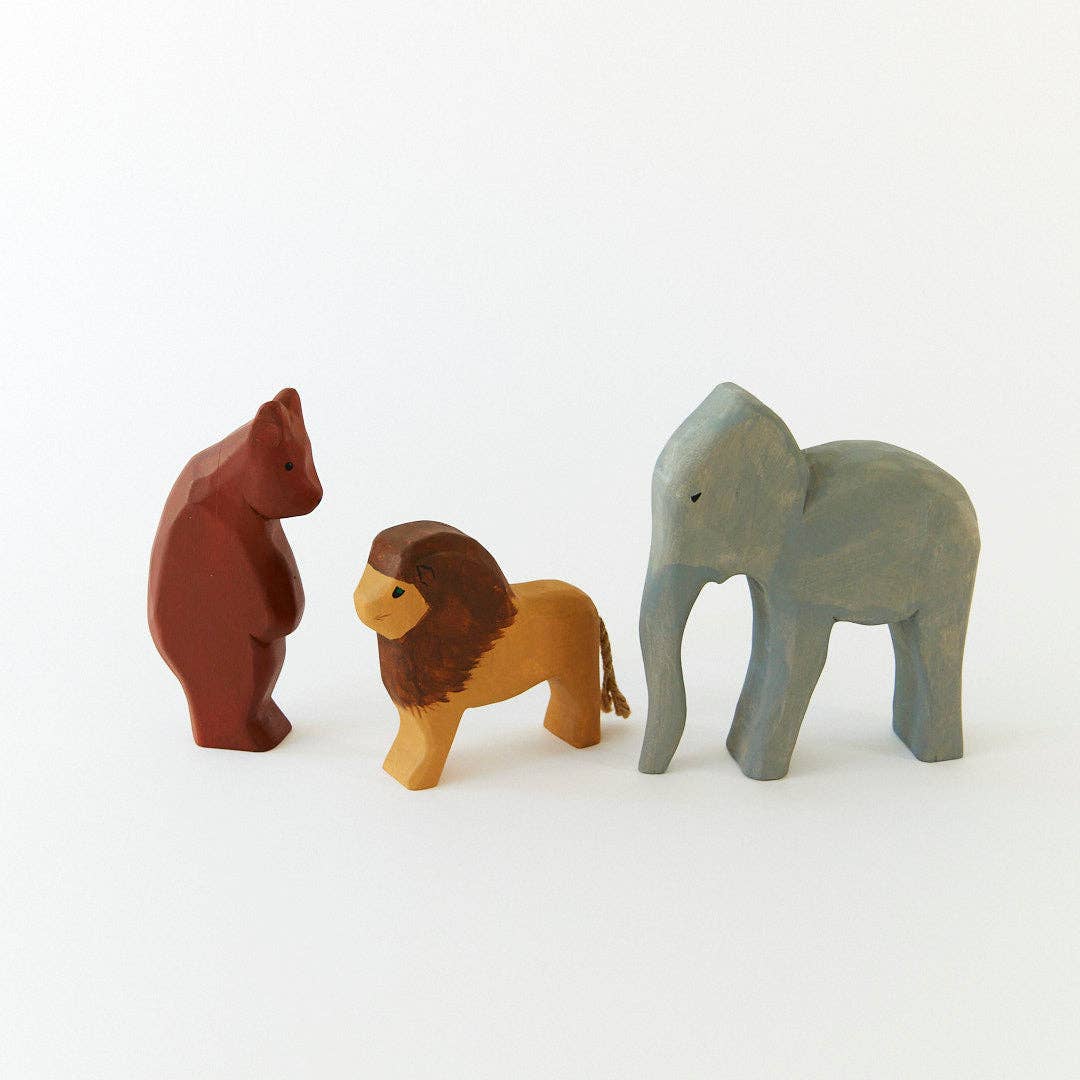Three wooden animal figurines on a white background