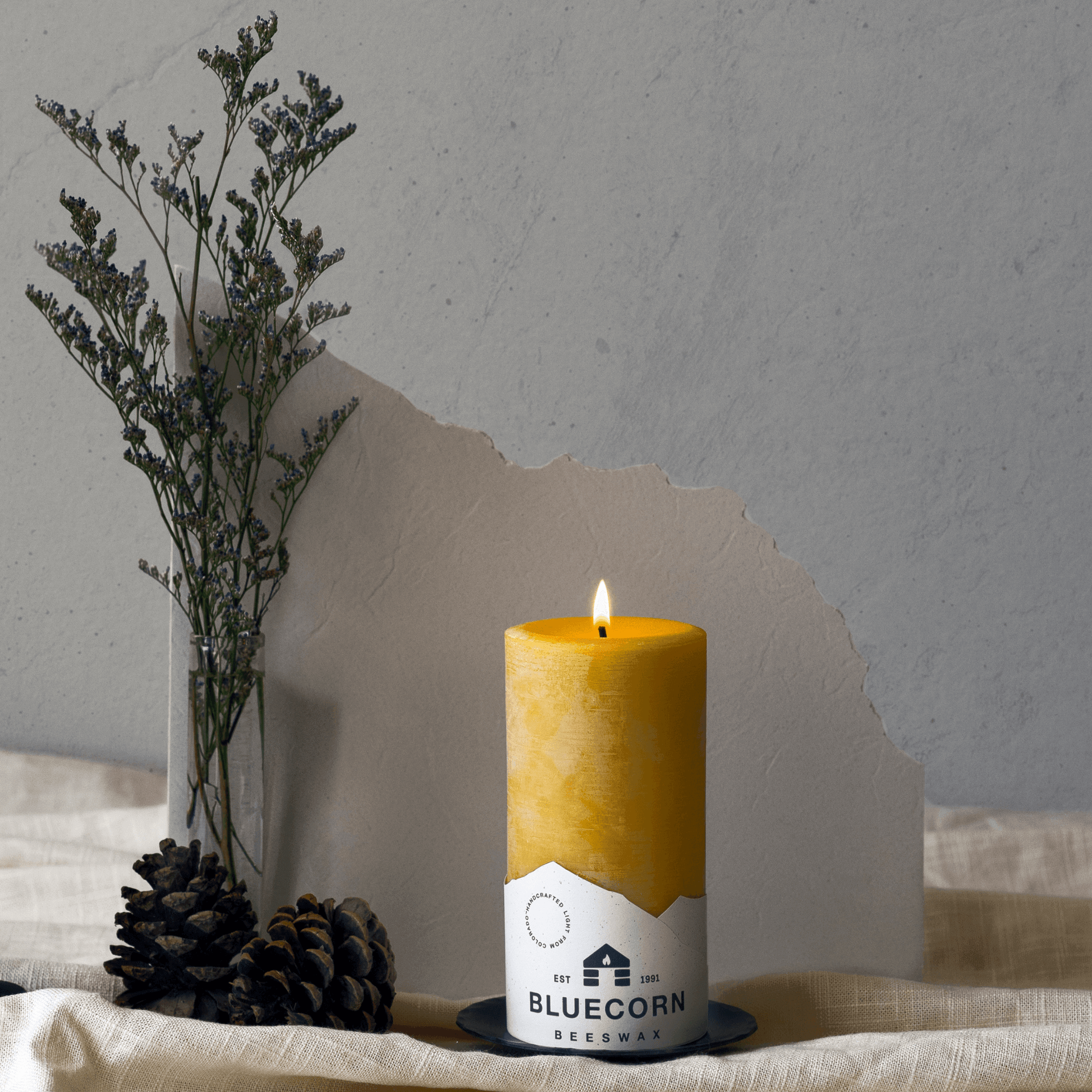 Candle with 'Bluecorn' branding on a neutral background